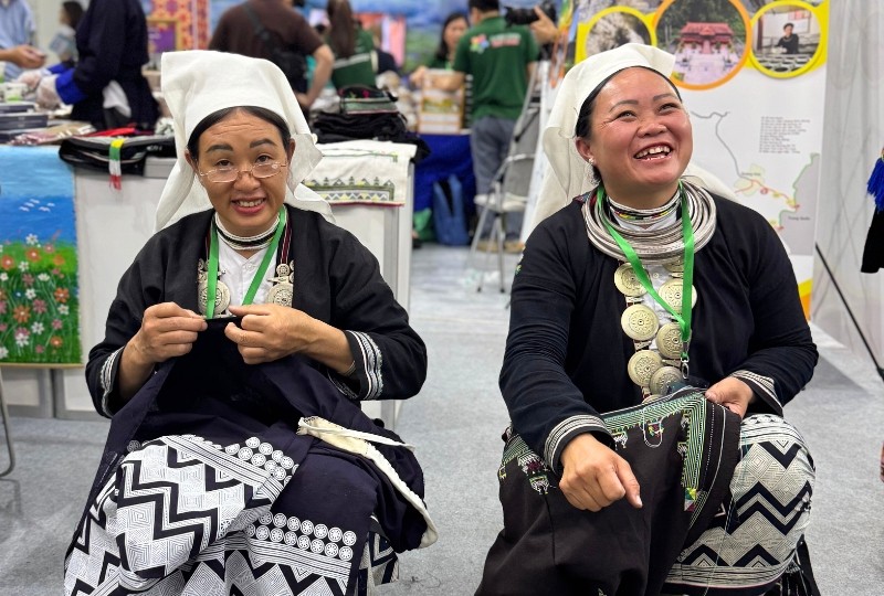 Chị Bàn Thị Liên vừa trình diễn nghề thủ công truyền thống, vừa giao lưu với người dân Thủ đô và du khách. Ảnh: Hồng Hạnh.