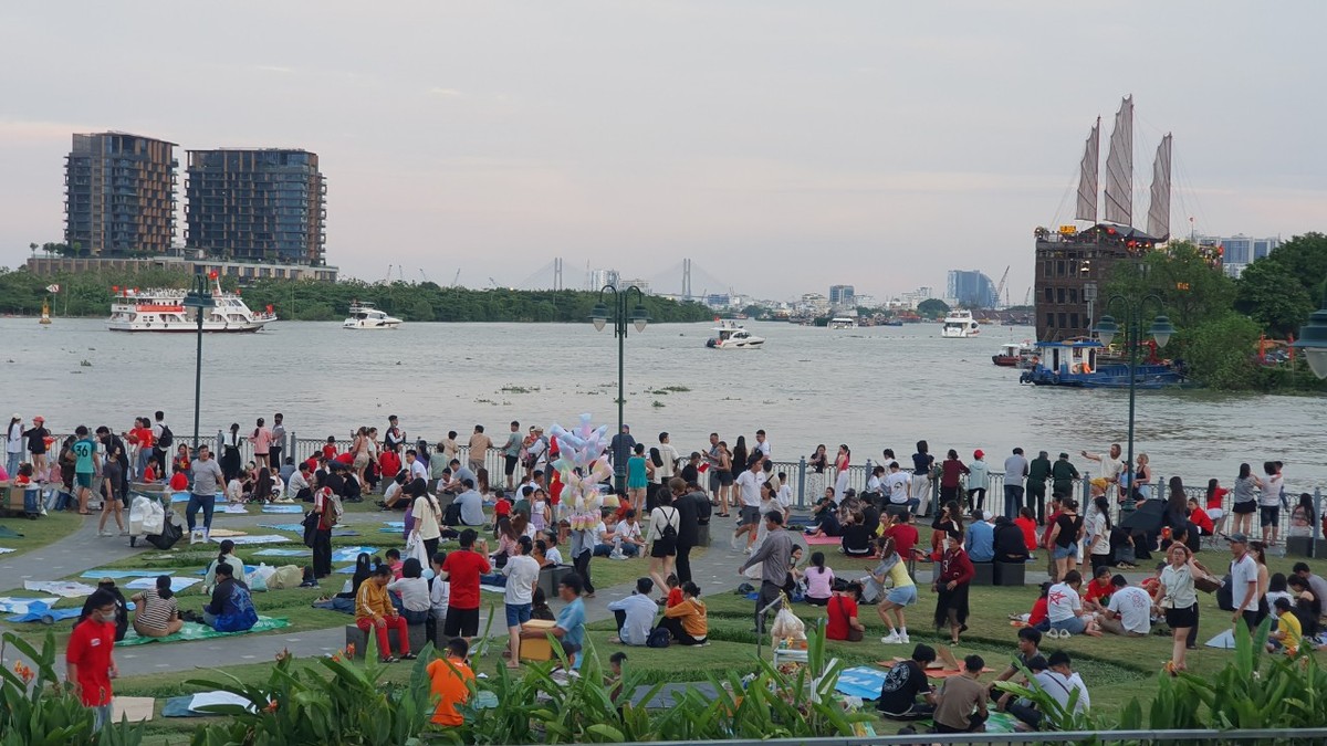 Hàng nghìn người ngày từ chiều đã tranh thủ giữ chỗ tại bờ sông Sài Gòn, nơi sẽ tổ chức bắn pháo hoa và nhiều hoạt động thể thao nước đặc sắc