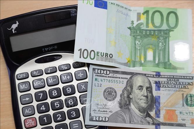 Đồng tiền mệnh giá 100 euro và 100 USD tại Brussels, Bỉ. (Ảnh: THX/TTXVN)