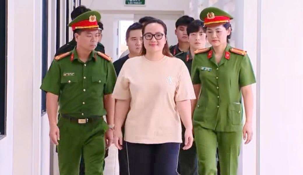 Hoàng Thị Hường bị lực lượng cảnh sát dẫn giải. (Ảnh từ clip của VTV) Hoàng Thị Hường bị lực lượng cảnh sát dẫn giải. (Ảnh từ clip của VTV)