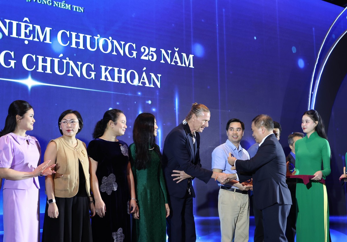 Ông Dominic Scriven, OBE, Chủ tịch Công ty Quản lý Quỹ Dragon Capital Việt Nam nhận kỷ niệm chương từ ông Lương Hải Sinh, Chủ tịch Hội đồng thành viên SGDCK Việt Nam (Ảnh: Lê Toàn)