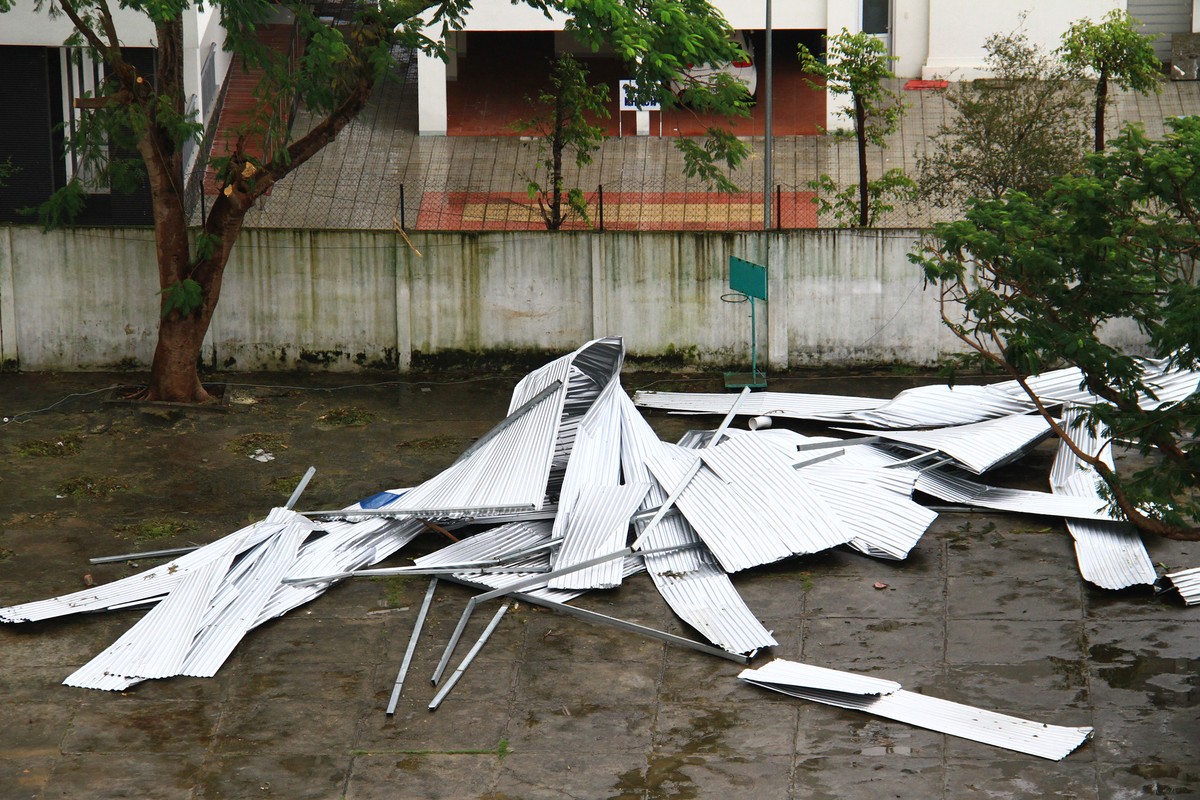 Mái tôn bị bão thổi rơi, nằm la liệt trên sân. Mái tôn bị bão thổi rơi, nằm la liệt trên sân.
