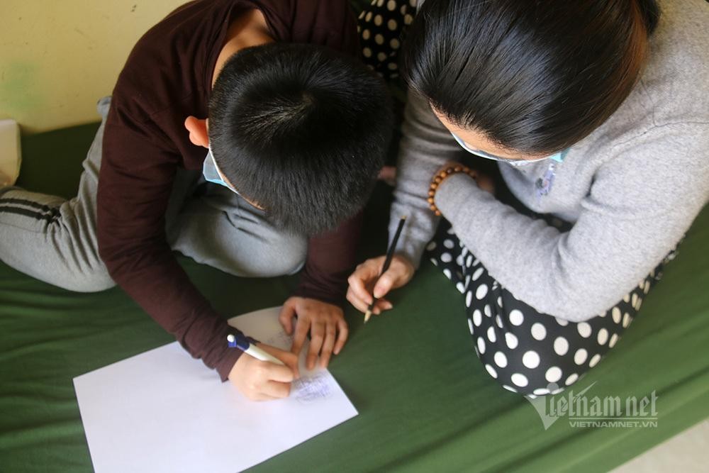 Bà mẹ tuy chỉ là F2 nhưng tình nguyện vào khu cách ly để chăm sóc cho cậu con trai là F1. Hai mẹ con đang chơi cờ ca-rô.