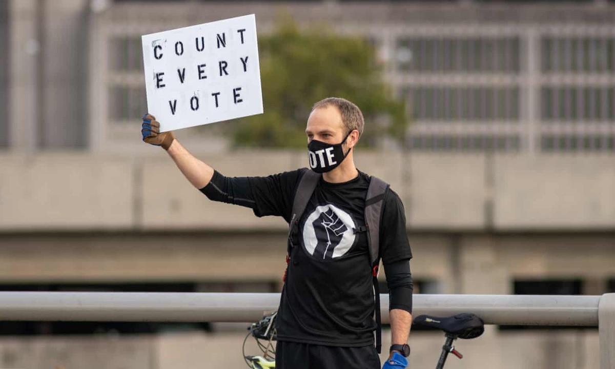 Một người biểu tình tại Atlanta giơ cao biểu ngữ Một người biểu tình tại Atlanta giơ cao biểu ngữ