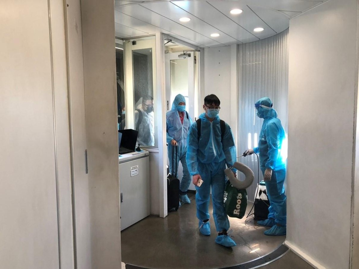 Hành khách được khử trùng khi xuống tàu bay.