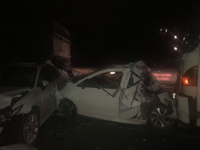 Hai chiếc ô tô chèn giữa bị tông bẹp dúm.