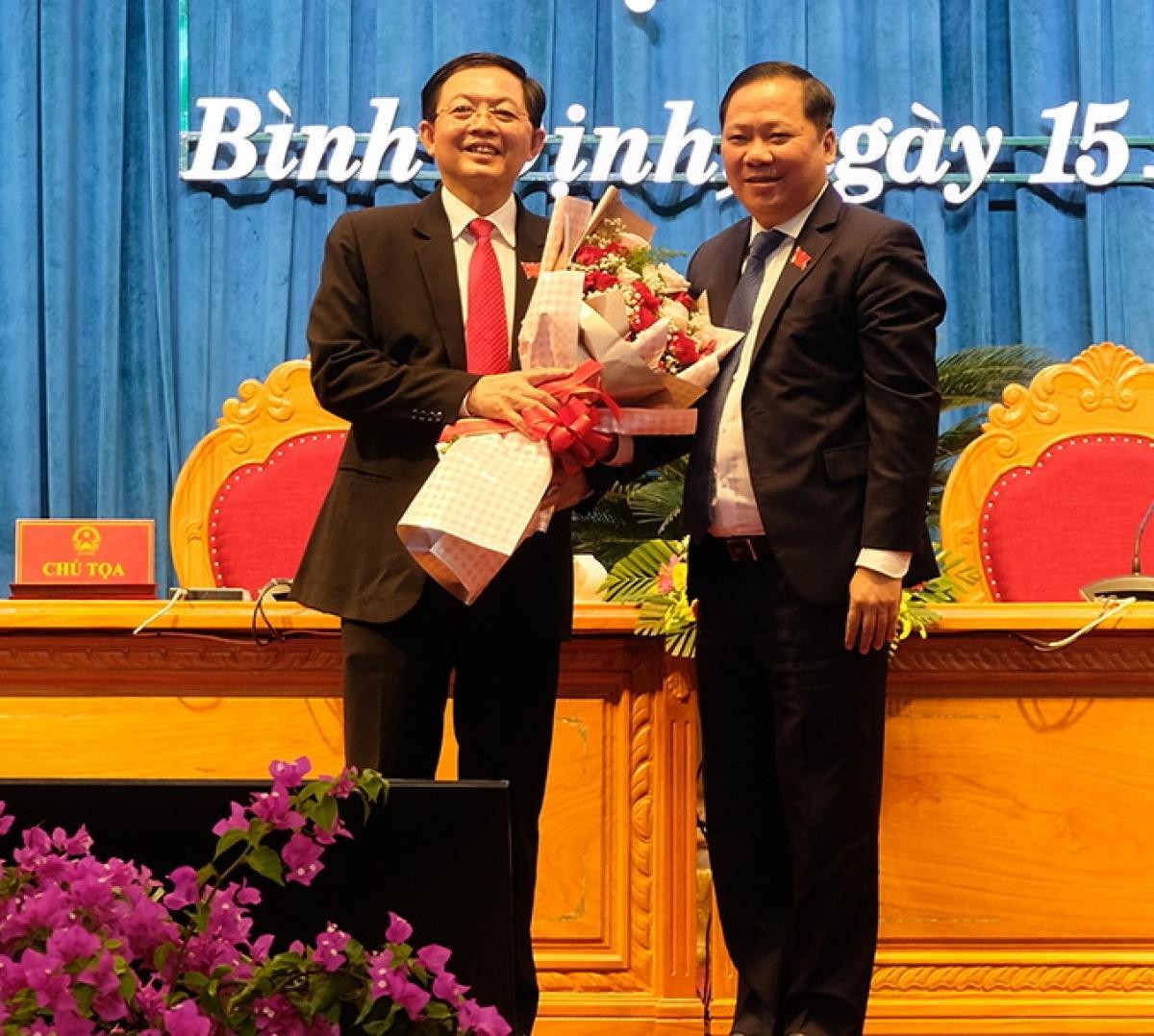 Ông Nguyễn Phi Long, Chủ tịch UBND tỉnh Bình Định (bên phải) tặng hoa ông Hồ Quốc Dũng, Bí thư Tỉnh ủy vừa được bầu lại làm Chủ tịch HĐND tỉnh khóa XIII.
