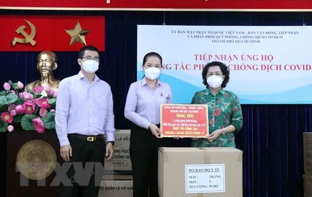 Tô Thị Bích Châu (phải), Chủ tịch Ủy ban MTTQ Việt Nam Thành phố tiếp nhận tượng trưng tiền mặt, hàng hóa ủng hộ của Đảng ủy Khối Dân-Chính-Đảng Thành phố Hồ Chí Minh. (Ảnh: Xuân Khu/TTXVN).