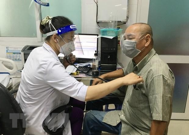 Bác sỹ Bệnh viện quận 7 khám bệnh cho người dân. (Ảnh: Đinh Hằng/TTXVN).
