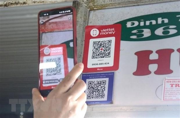 Khách hàng quét mã QR-code khi mua sắm tại chợ Cồn. (Ảnh: Quốc Dũng/TTXVN).