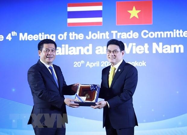 Phó Thủ tướng, Bộ trưởng Thương mại Thái Lan Jurin Laksanawisit (phải) tặng quà Bộ trưởng Công thương Nguyễn Hồng Diên. (Ảnh: TTXVN).