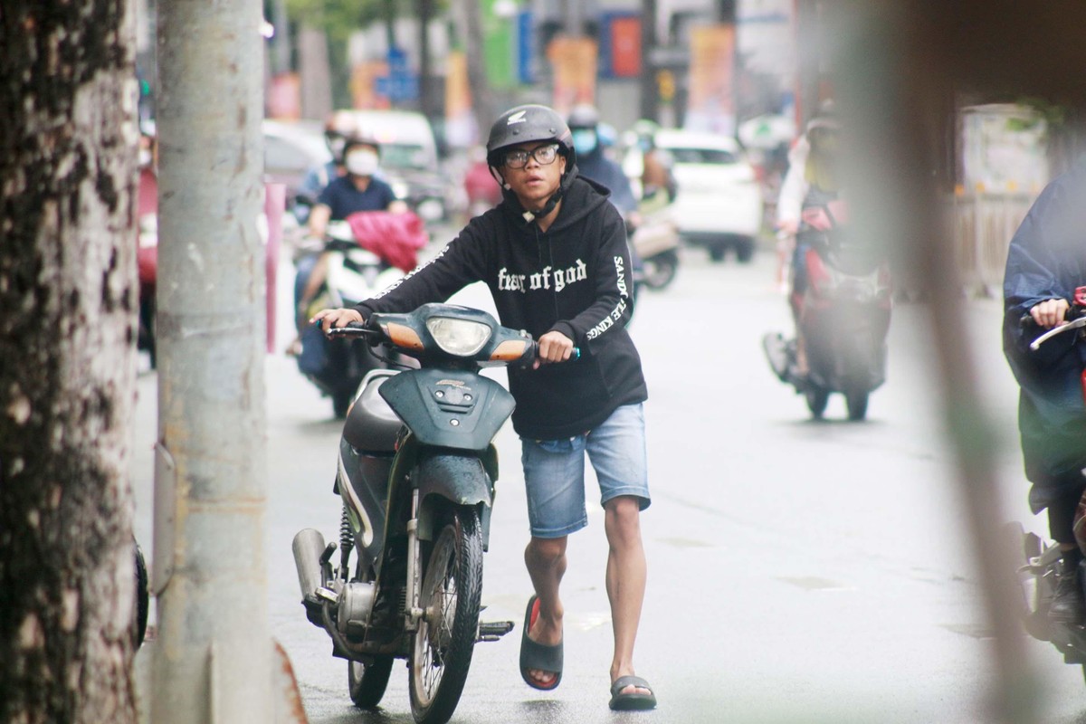 Anh Tuấn dắt xe hơn 2 km trên đường Trần Hưng Đạo, quận 1 cho biết, đi qua hai cây xăng đều bị lắc tay từ chối.