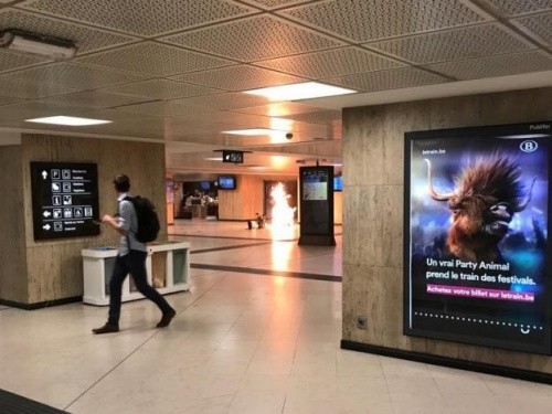Người đàn ông nhìn vụ nổ bùng lên A man looks back as an explosion inside the central station in Brussels is caught on camera.