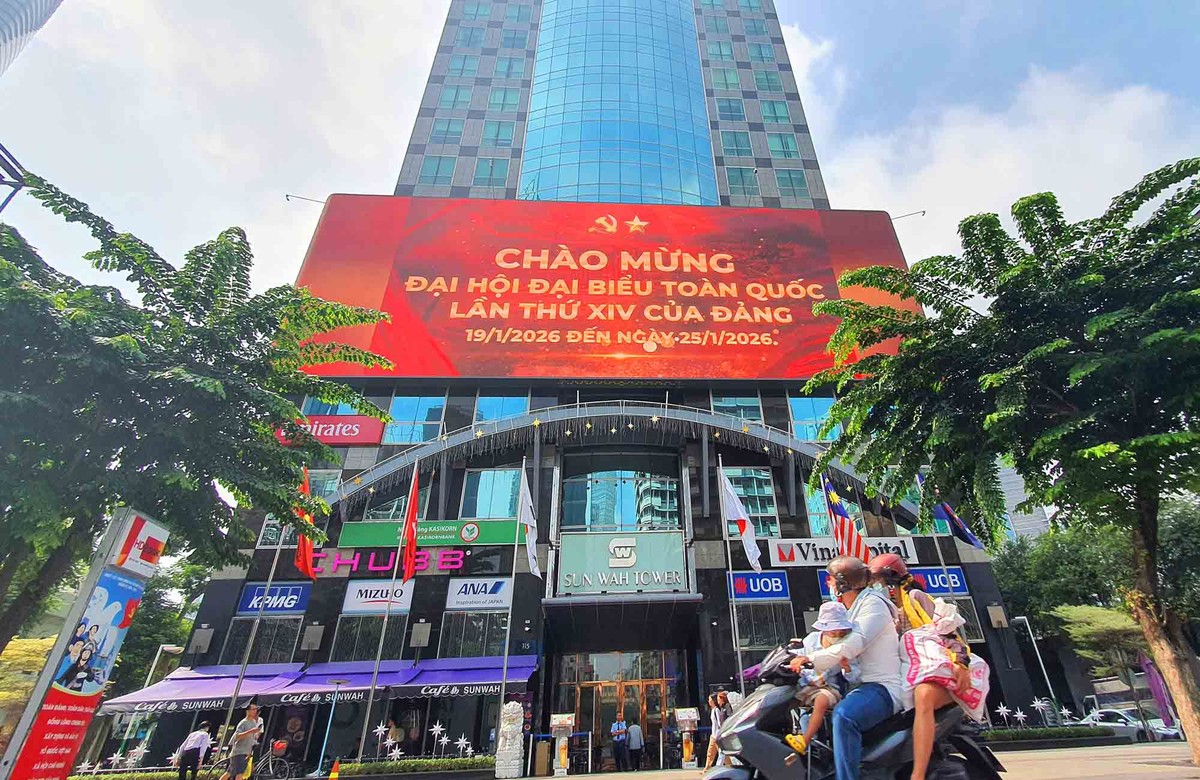 Thông điệp chào mừng Đại hội Đảng nổi bật trên màn hình LED giữa không gian trung tâm TP.HCM, hòa cùng nhịp sinh hoạt thường ngày của người dân.