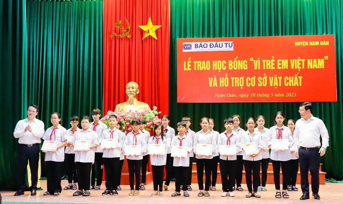 Thứ trưởng Bộ Kế hoạch và Đầu tư Trần Quốc Phương và ông Nguyễn Đức Trung - Chủ tịch UBND tỉnh Nghệ An trao học bổng và giấy chứng nhận cho các em học sinh tiêu biểu.