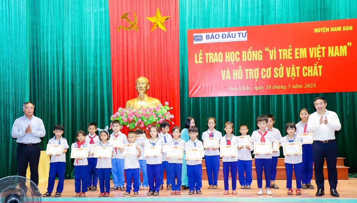Ông Lê Trọng Minh và ông Nguyễn Xuân Đức (phải), Bí thư Huyện Uỷ huyện Nam Đàn trao học bổng và giấy chứng nhận cho các em học sinh tiêu biểu.