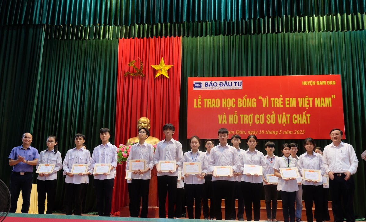 Đại diện nhà tài trợ và UBND huyện Nam Đàn trao học bổng và giấy chứng nhận cho các em học sinh tiêu biểu.