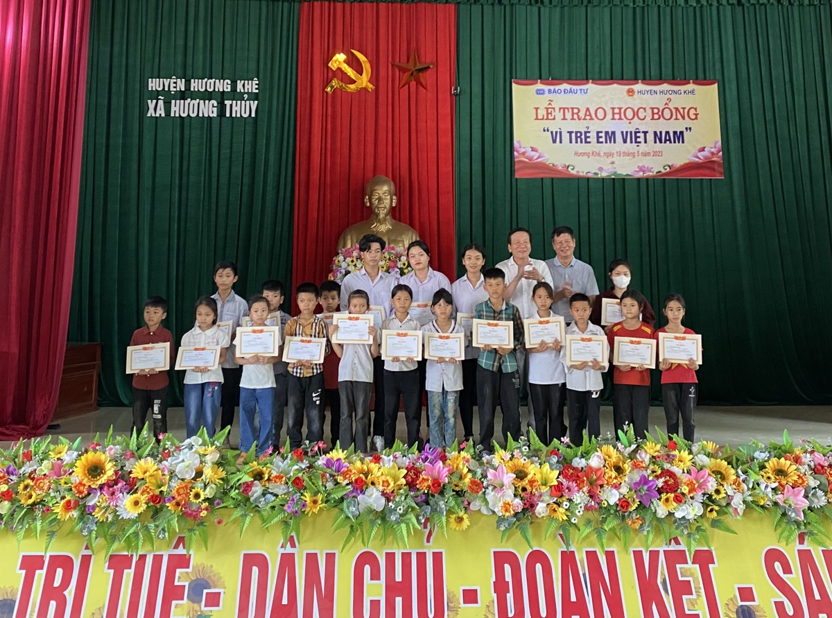 Ông Nguyễn Anh Tuấn (hàng dưới, thứ hai từ phải), nguyên Tổng Biên tập Báo Đầu tư và đại diện nhà tài trợ trao giấy khen và học bổng cho các em học sinh.