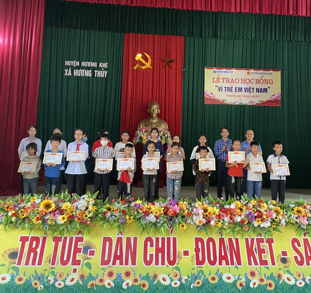 Ông Bùi Đức Hải (hàng dưới, thứ 2 từ phải), Phó Tổng Biên tập Thường trực Báo Đầu tư và đại diện nhà tài trợ trao giấy khen và học bổng cho các em học sinh