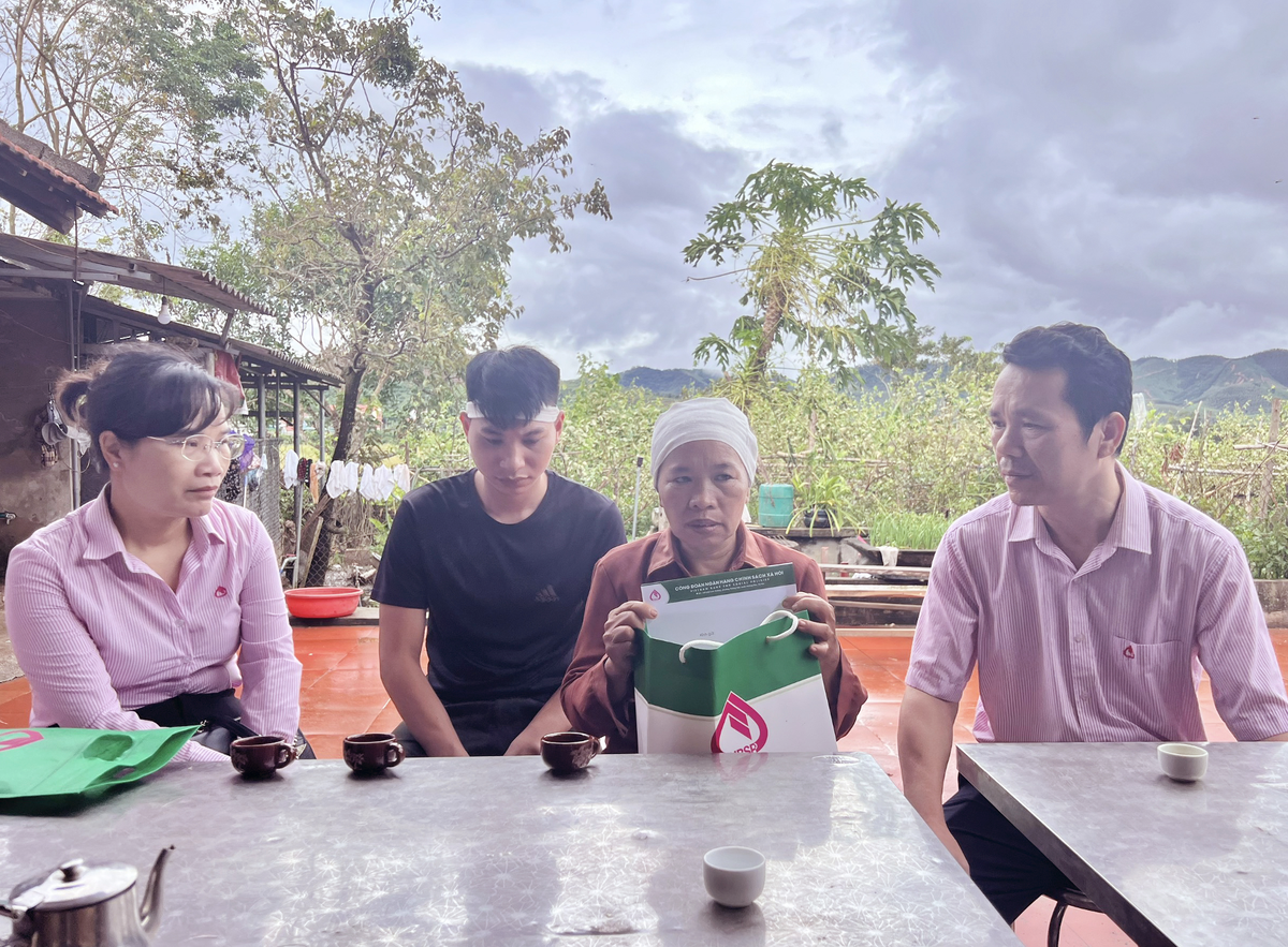 Phó tổng giám đốc Hoàng Minh Tế (bên phải) động viên, chia sẻ với gia đình bà Đinh Thị Song ở thôn Thùng Thìn, xã Biển Động, huyện Lục Ngạn