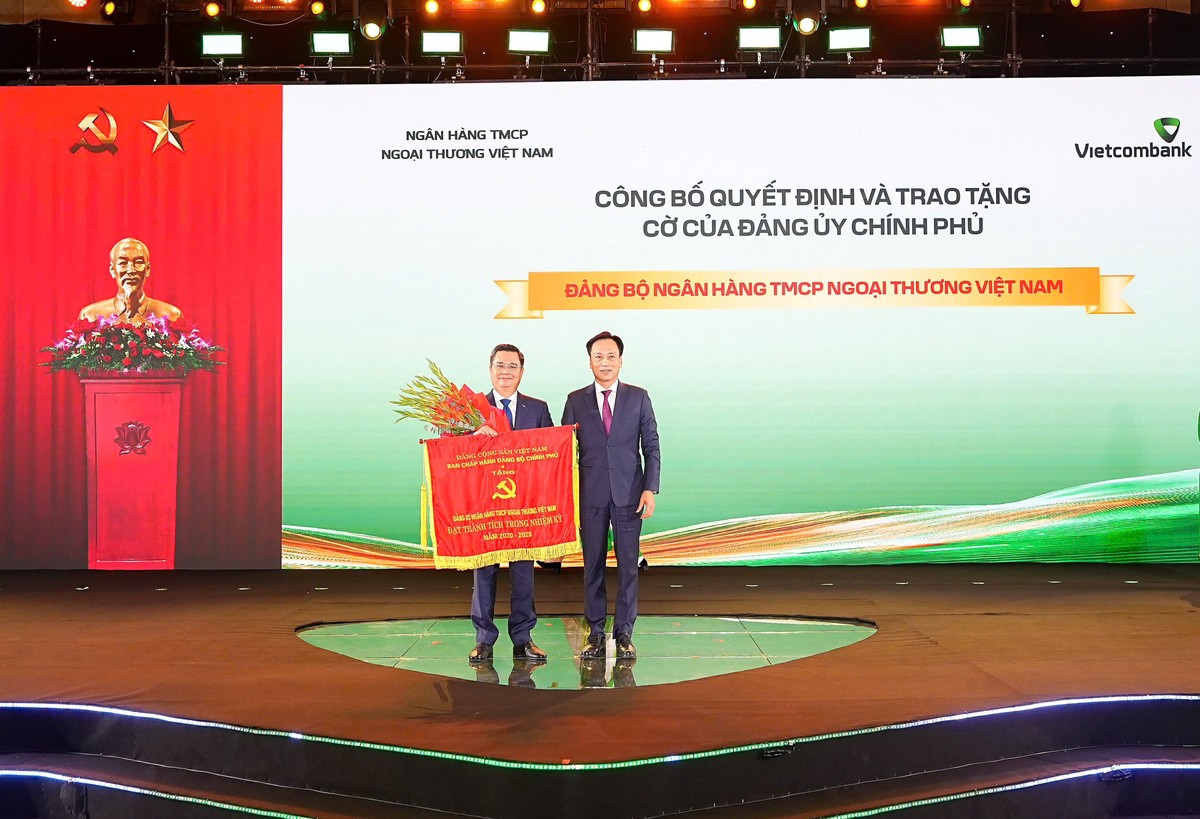 Ông Nguyễn Thanh Tùng - Bí thư Đảng ủy, Chủ tịch HĐQT Vietcombank đại diện Đảng bộ ngân hàng đón nhận cờ thi đua của Đảng ủy Chính phủ vì đã có thành tích trong nhiệm kỳ 5 năm 2020-2025 do ông Lại Xuân Lâm , Phó Bí thư Chuyên trách Đảng ủy Chính phủ trao tặng