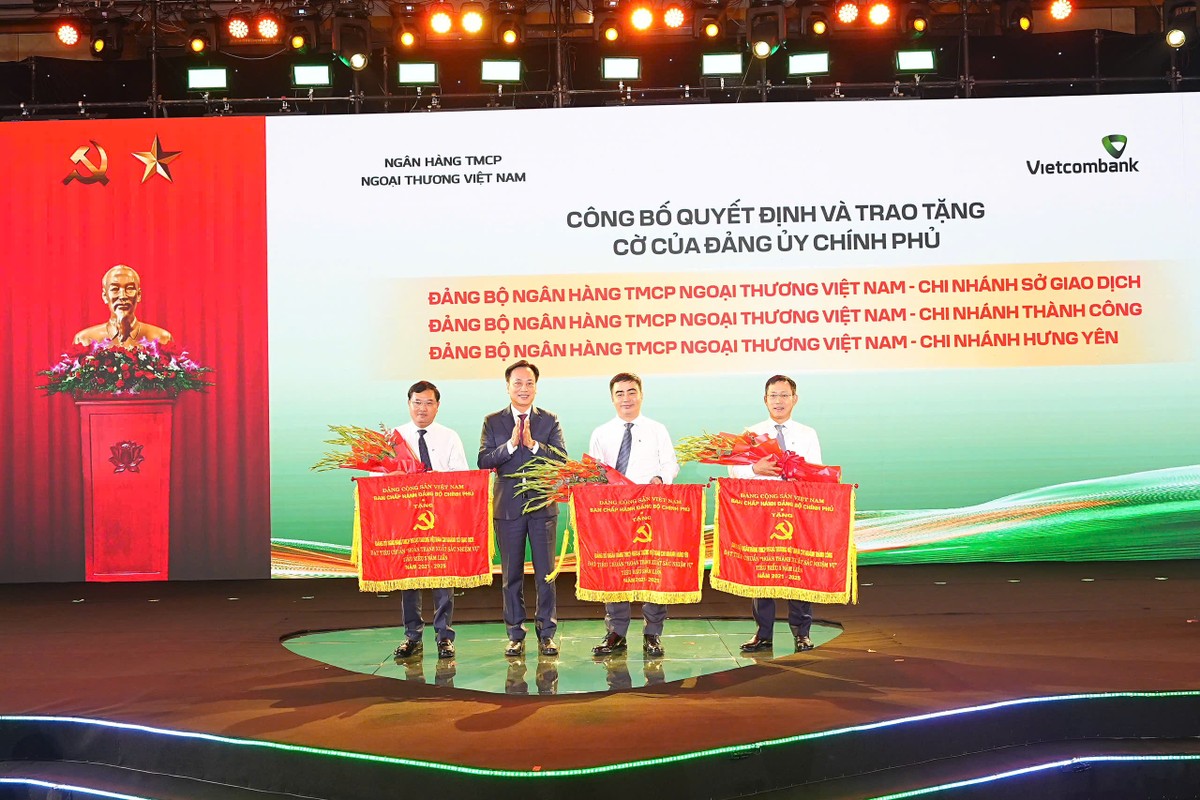Đại diện Đảng ủy Chính phủ, ông Lại Xuân Lâm - Phó Bí thư Chuyên trách trao cờ và tặng hoa cho đại diện 03 Đảng bộ trực thuộc Vietcombank được công nhận đạt tiêu chuẩn hoàn thành xuất sắc nhiệm vụ tiêu biểu giai đoạn 2021-2025, gồm: Đảng bộ Chi nhánh Sở Giao dịch, Chi nhánh Thành Công và Chi nhánh Hưng Yên