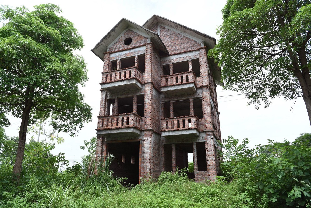 Những căn biệt thự được xây dựng xong phần thô, đã bỏ hoang hơn một thập kỷ, với sân vườn là cỏ mọc che kín lối vào. Những căn biệt thự được xây dựng xong phần thô, đã bỏ hoang hơn một thập kỷ, với sân vườn là cỏ mọc che kín lối vào.