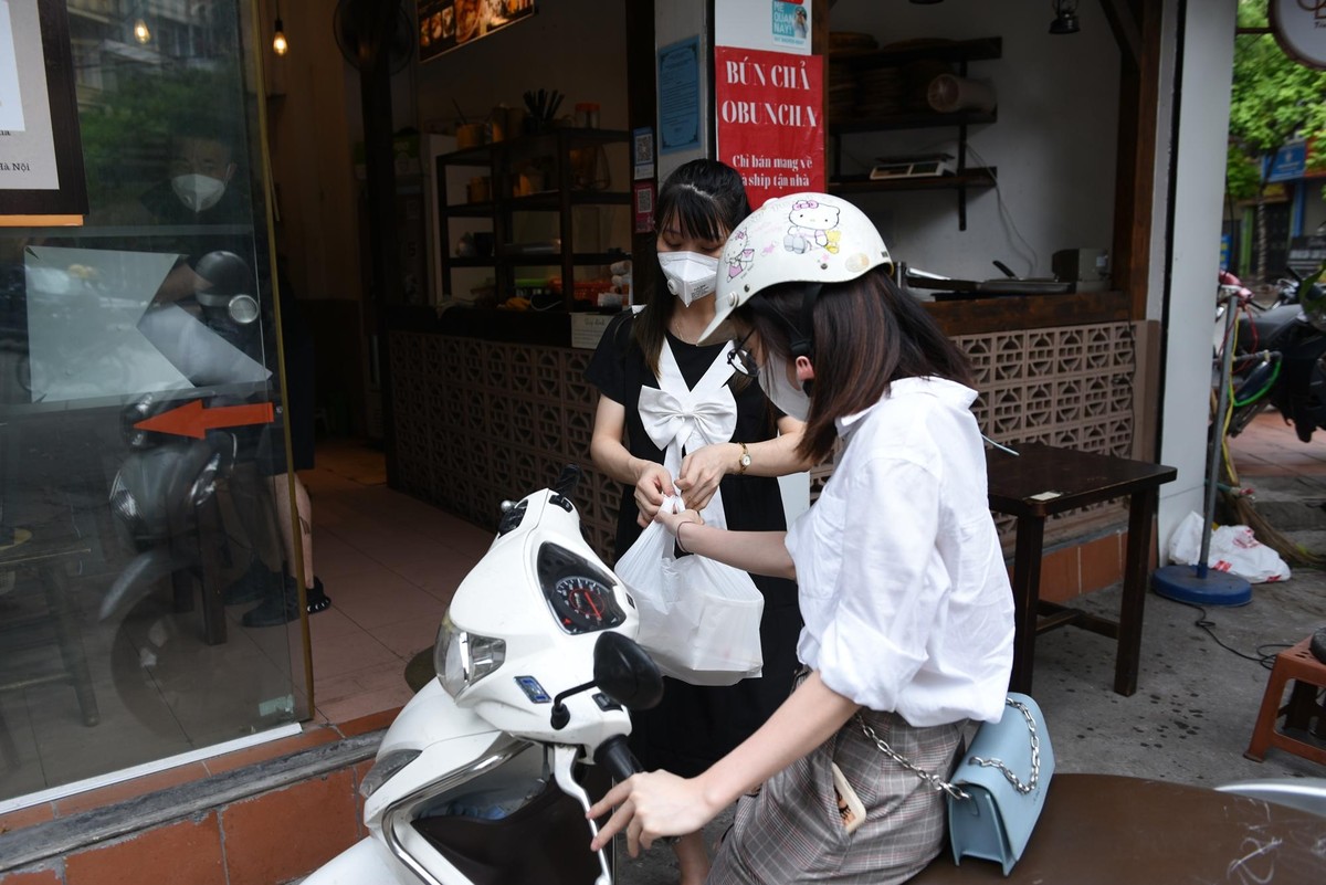 "Hàng quán được mở cửa bán hàng mang về giúp tôi chủ động được hơn rất nhiều về thời gian", chị Thu Hằng, nhân viên một công ty đi làm trong mùa dịch cho biết.