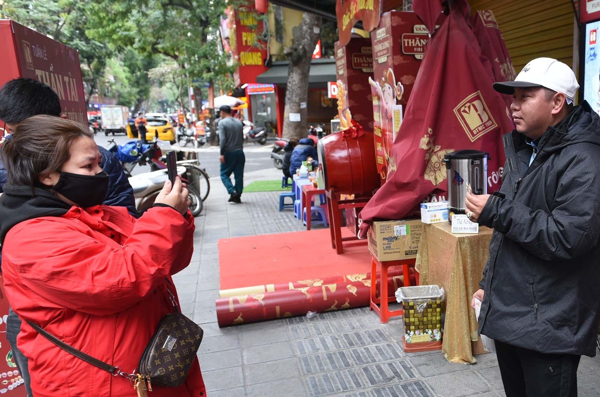 Vợ chồng anh Chiến (Hà Đông) chụp ảnh kỷ niệm sau khi mua vàng. "Tôi tâm niệm không cúng muộn là được rồi, đi mua sớm cho đỡ đông người" anh Chiến nói.