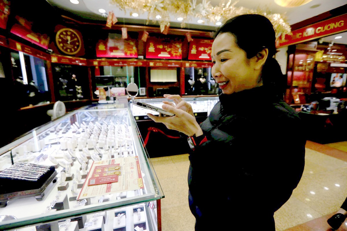 Khách hàng vui sướng chụp hình với vàng Thần tài vừa mua được