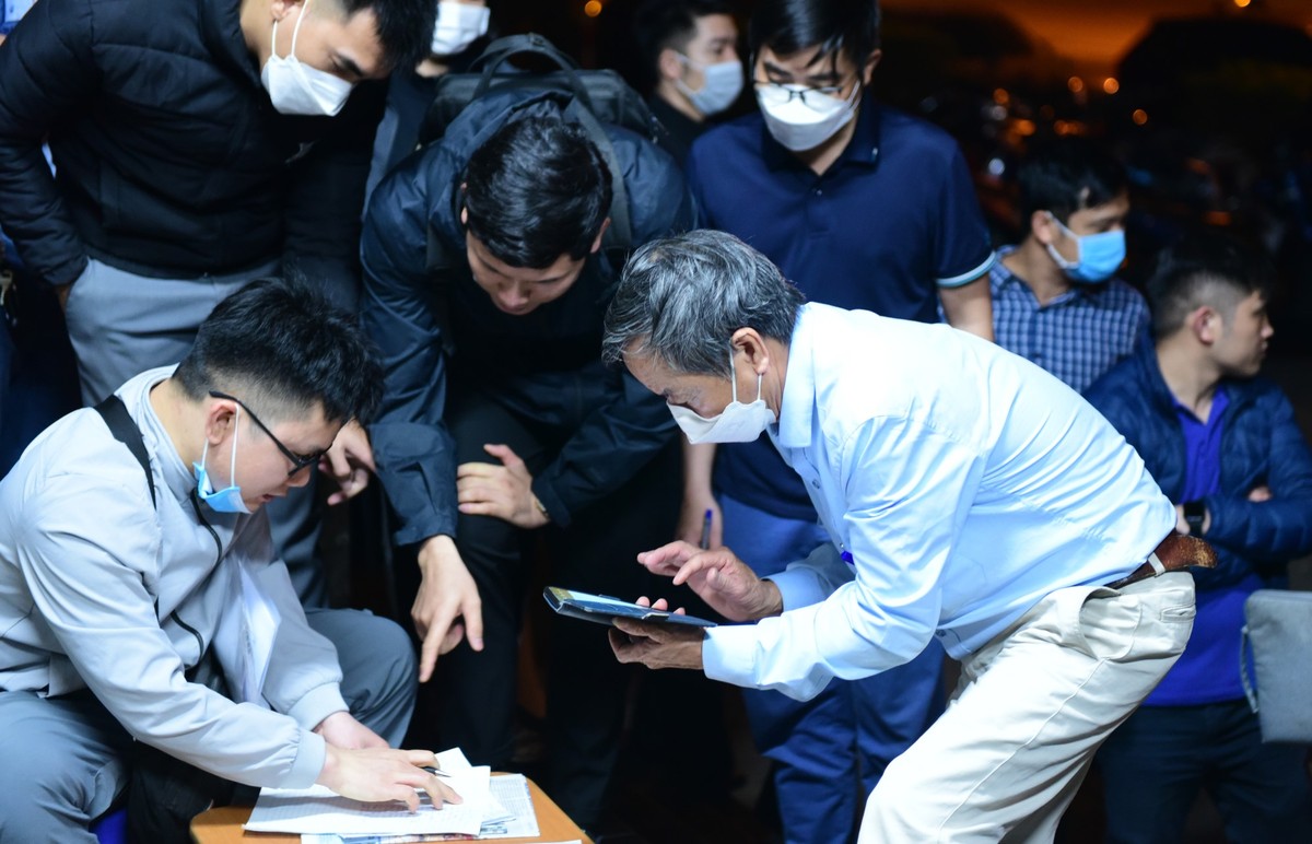 Ông Phạm Duy Hòa (cầm điện thoại) là người đầu tiên đến xếp hàng. Ông cho biết đã đến 2 lần nhưng không thể nộp được hồ sơ do quá đông người đăng ký trước. "Lần này tôi đã đợi từ 18h bỏ cả ăn tối ở đây để đứng đầu danh sách" ông Hòa nói.