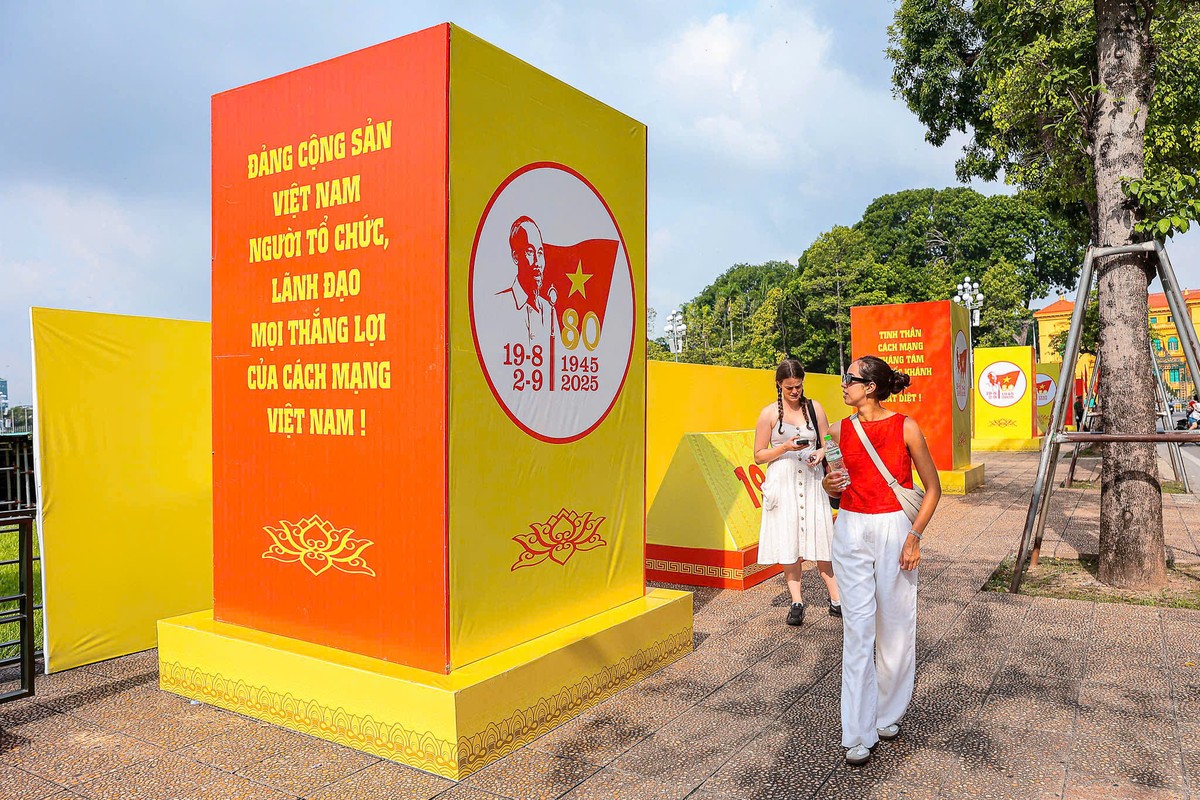 Du khách nước ngoài thích thú với những tấm pano, áp phích được đặt tại Quảng trường Ba Đình.