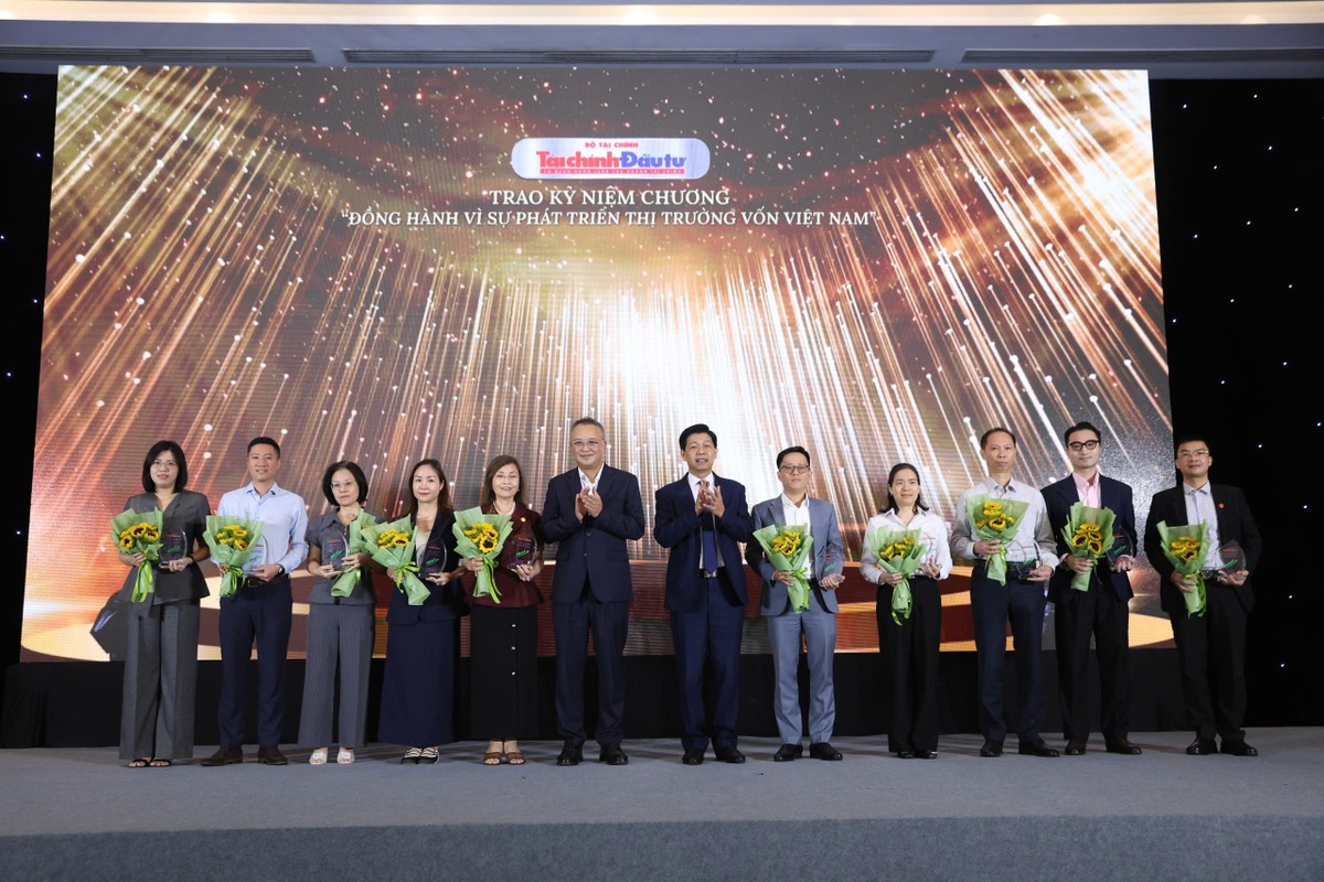 Đại diện các công ty nhận kỷ niệm chương chụp ảnh lưu niệm với ông Bùi Hoàng Hải, Phó chủ tịch UBCK và ông Phạm Văn Hoành, Tổng Biên tập Báo Tài chính - Đầu tư.