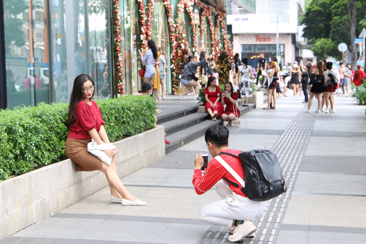 Các bạn trẻ chụp hình cho nhau để kỷ niệm mùa giáng sinh mới.