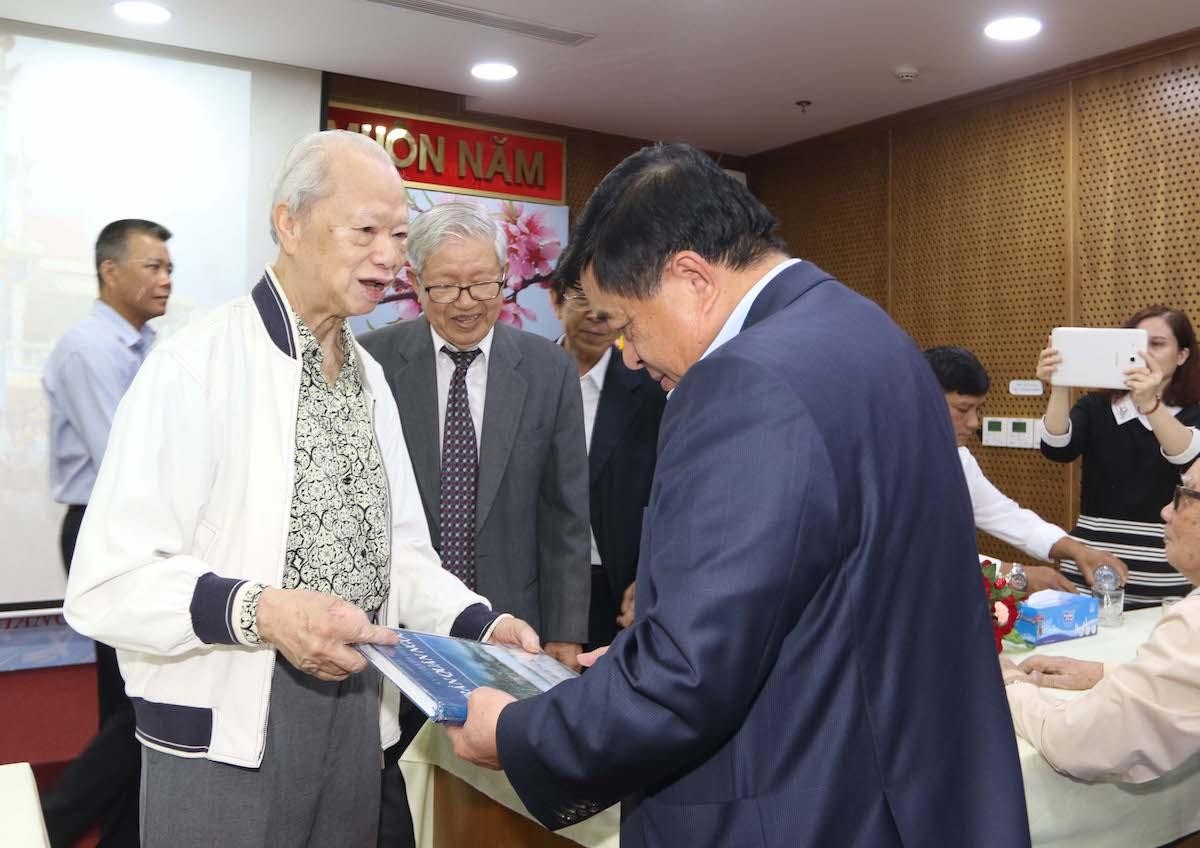 Ông Trần Quân Ngọc, cán bộ hưu trí tặng sách đến Bộ trưởng Nguyễn Chí Dũng (Ảnh: Lê Toàn).