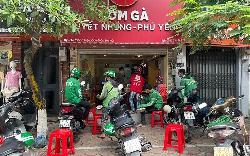 Ghi nhận tại nhiều hàng quán nổi tiếng, số lượng shipper chờ lấy đồ ăn để chuyển cho khách rất đông. (Ảnh: Phương Linh)