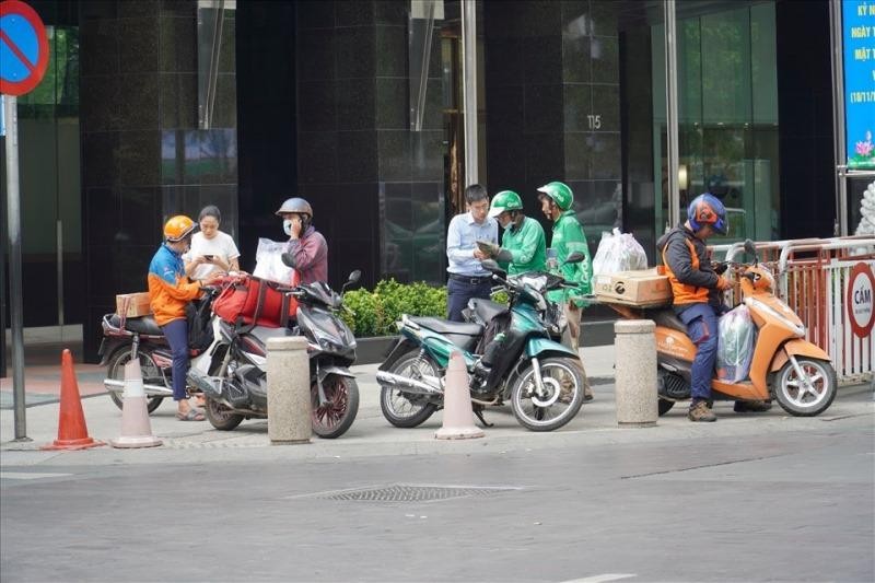 Shipper của các hãng vận chuyển tập trung giao hàng tại tòa chung cư quận Đống Đa sau dịp sale. (Ảnh: Phương Linh)