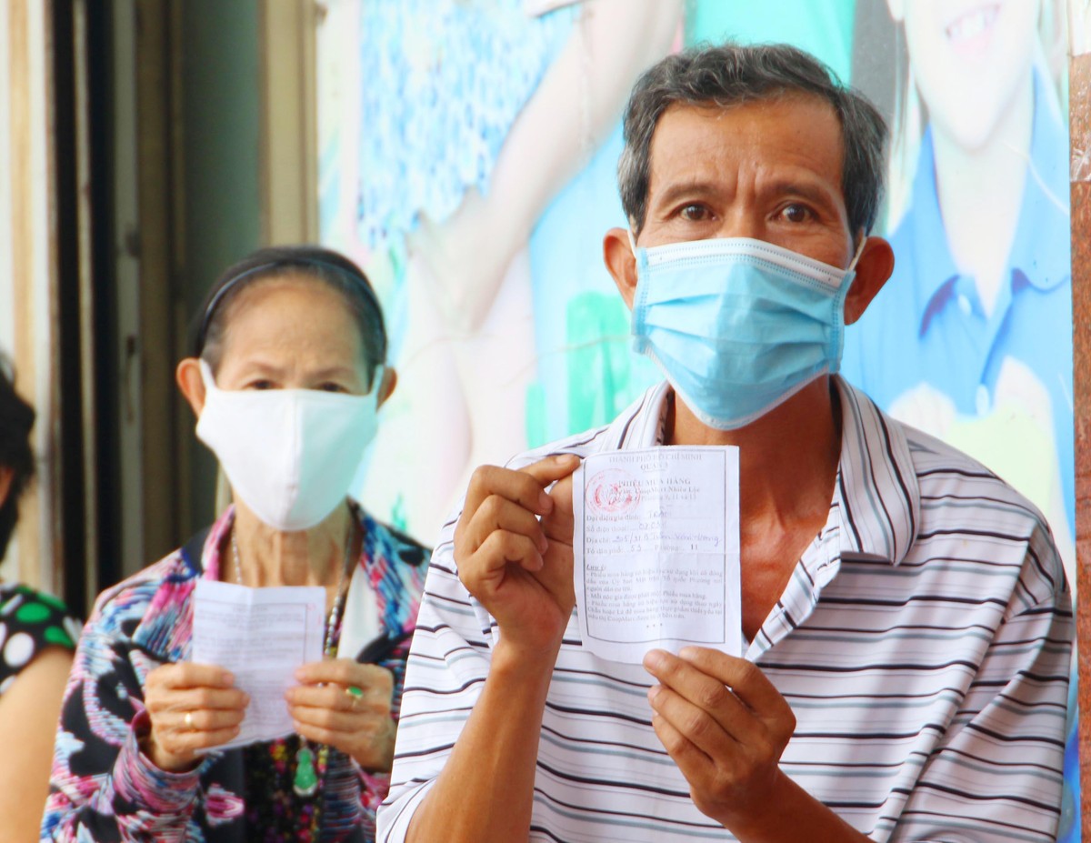 Khách hàng Trần Vũ, tổ dân phố 53, của Quận 3, được phát phiếu đi mua hàng ngày lẻ.