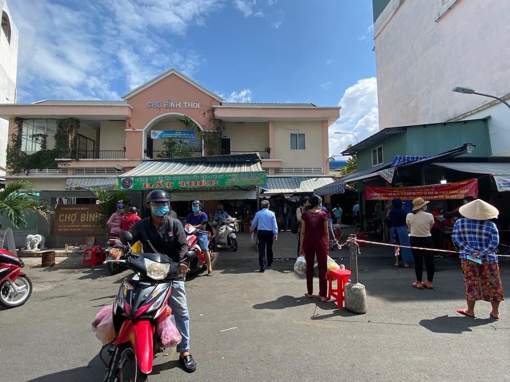 Người dân chợ Bình Thới quận 11 chờ phát đến lượt vào chợ (Ảnh minh hoạ: Q.T).