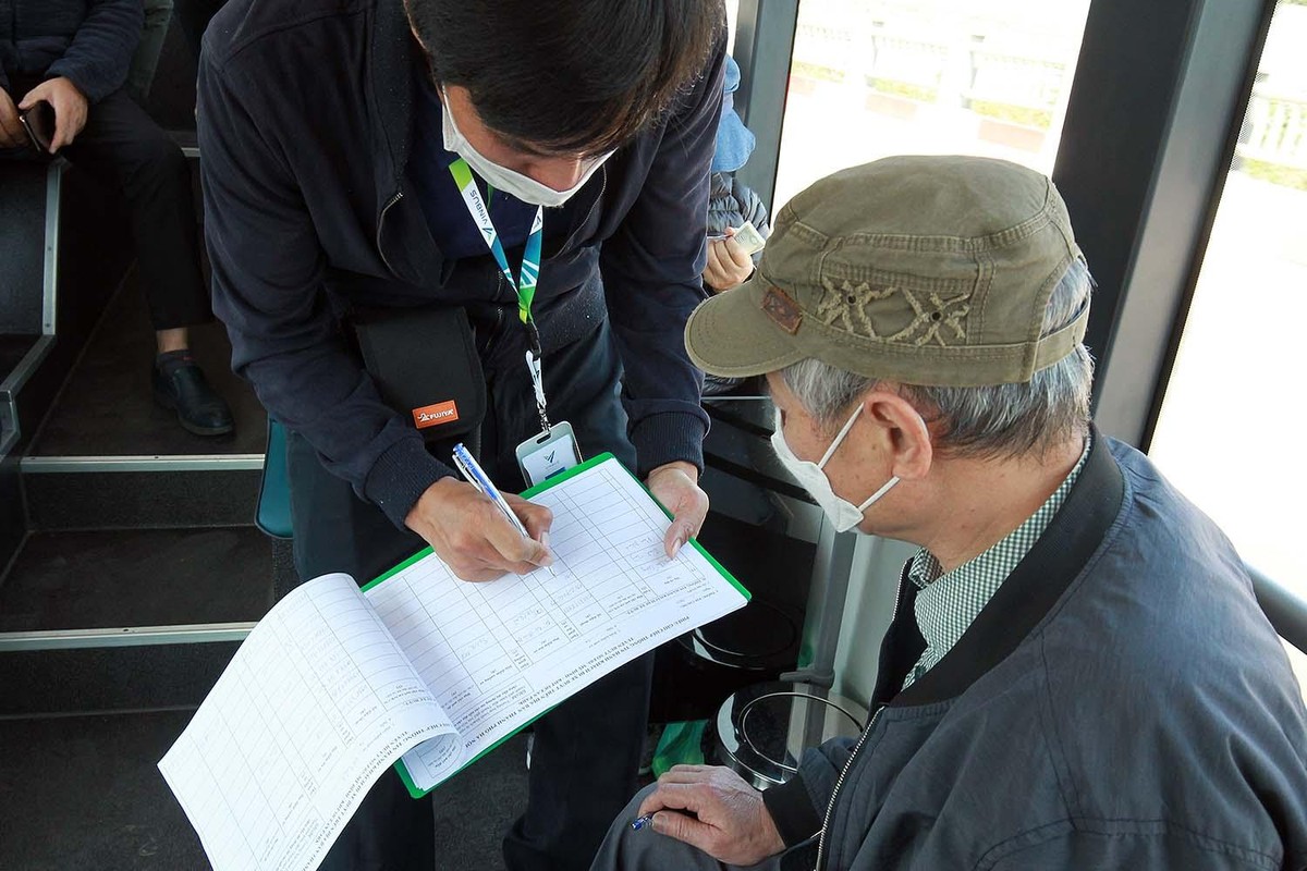 Khách hàng thực hiện quét mã QR, nhưng nhân viên xe buýt vẫn cẩn thận ghi lại tên, số điện thoại của khách hàng