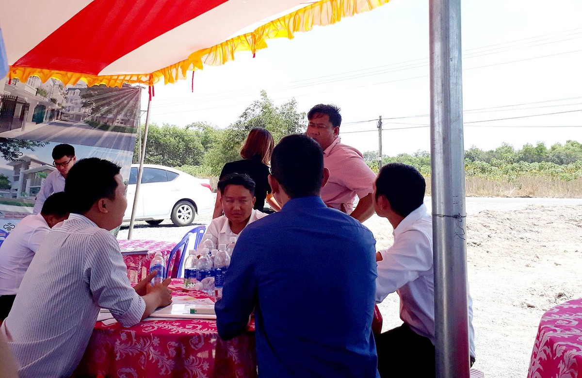 Môi giới tư vấn cho khách hàng xem đất tại Củ Chi. Ảnh: Việt Dũng