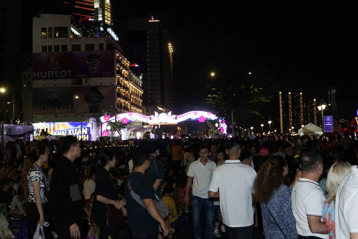 Khi thời khắc giao thời sắp điểm, dòng người vội vã từ đường hoa Nguyễn Huệ di chuyển đến khu vực sông để có những góc nhìn rõ nhất.
