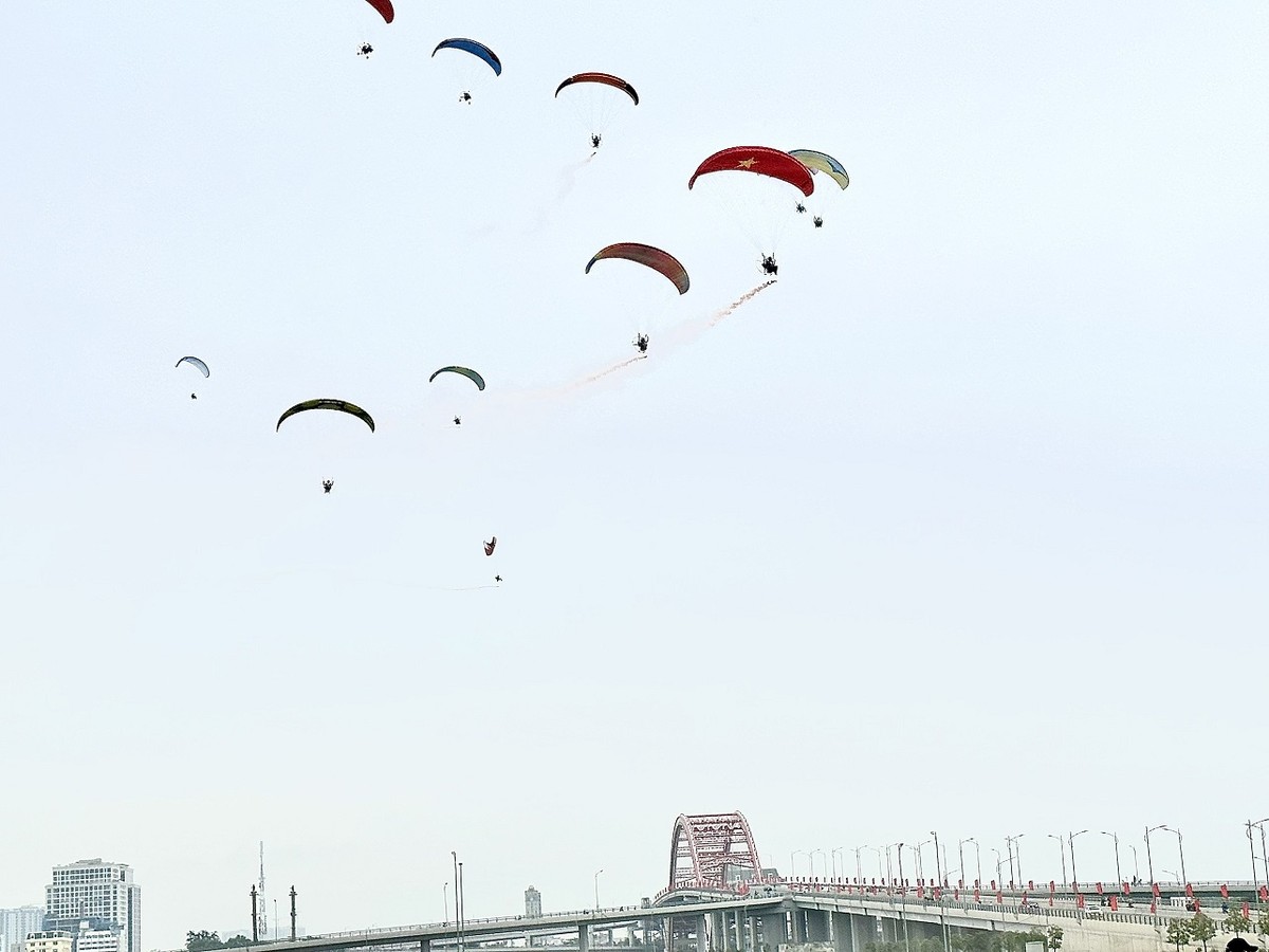 Các phi công biểu diễn theo đội hình mang theo cờ Tổ quốc bay lượn trên bầu trời Thành phố, thả pháo khói, pháo sáng. Ảnh: Quỳnh Nga