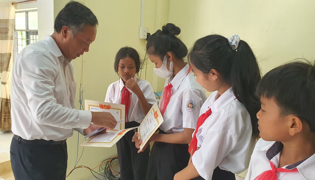 Tổng Biên tập Báo Đầu tư Lê Trọng Minh trao học bổng và động viên các em vượt khó vươn lên trong học tập.