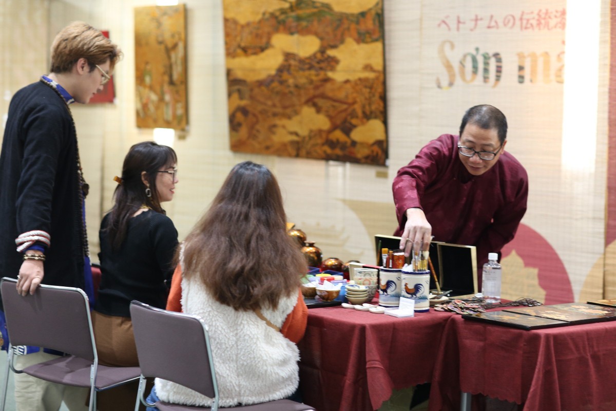 Họa sĩ Lương Minh Hòa hướng dẫn khách khắc, thếp bạc, mài để tạo nên một bức sơn mài khắc làm kỷ niệm. (Ảnh: Bộ Ngoại giao Việt Nam)