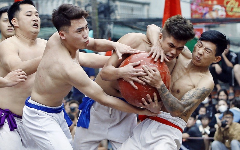 Các chàng trai giành giật, cản phá quyết liệt nhau để tranh quả cầu gỗ mít.