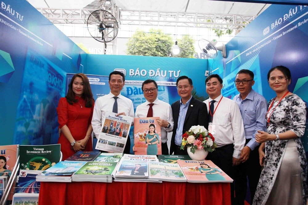 Bộ trưởng Bộ Thông tin và Truyền thông Nguyễn Mạnh Hùng (thứ hai, bên trái) và Chủ tịch Hội Nhà báo Việt Nam Lê Quốc Minh (thứ ba, bên trái) tham quan gian hàng trưng bày Báo Đầu tư. Ảnh: Lê Toàn