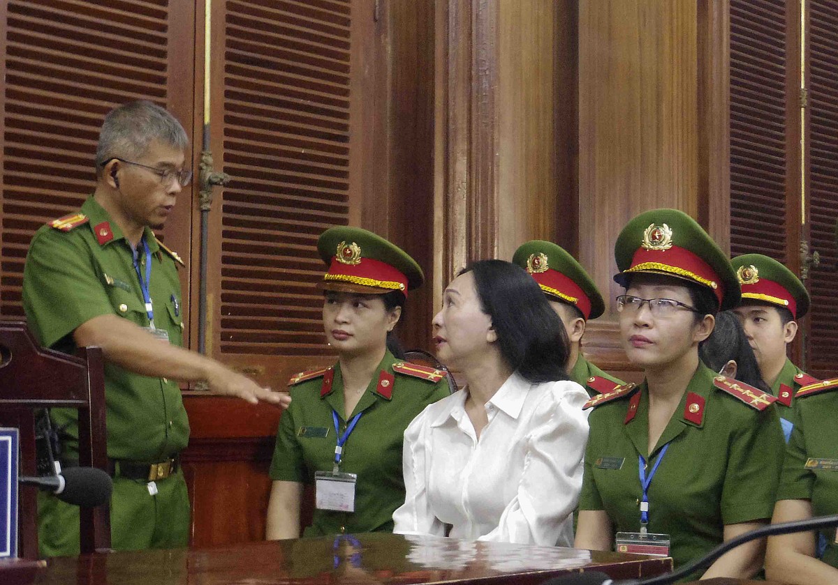 Bị cáo Lan trao đổi với cán bộ áp giải trước phiên tòa.