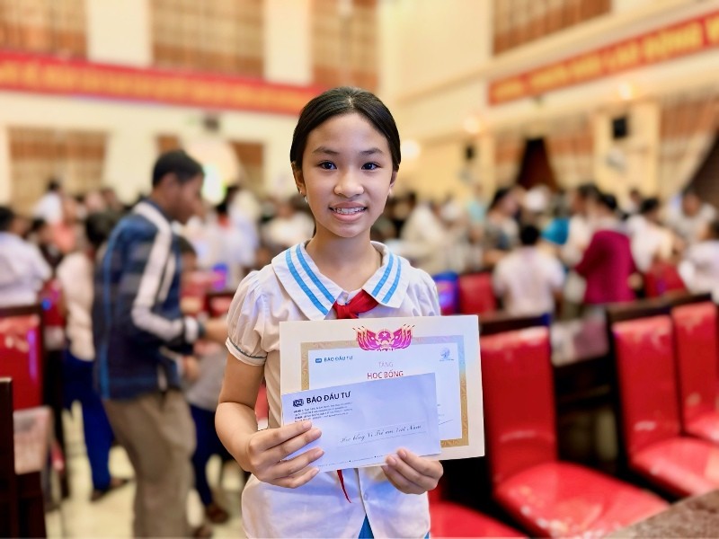 Nụ cười của học sinh vượt khó khi nhận học bổng và giấy chứng nhận.