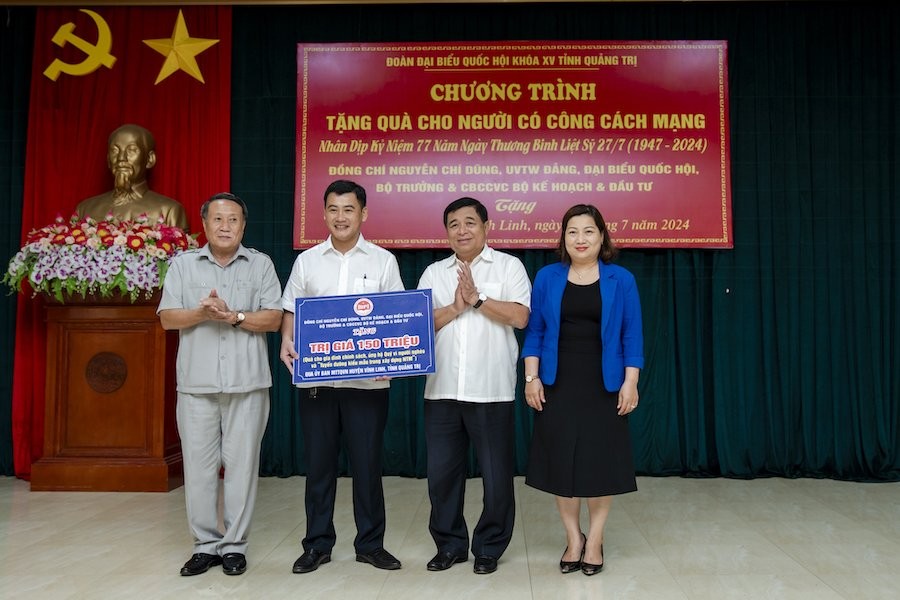 Bộ trưởng Nguyễn Chí Dũng và Chủ tịch Công đoàn Bộ KH&amp;ĐT Lê Thị Tường Thu trao quà của Bộ trưởng và cán bộ, công chức, viên chức, người lao động Bộ Kế hoạch và Đầu tư cho các gia đình người có công tại huyện Vĩnh Linh, Quảng Trị. Ảnh: Trường Sơn